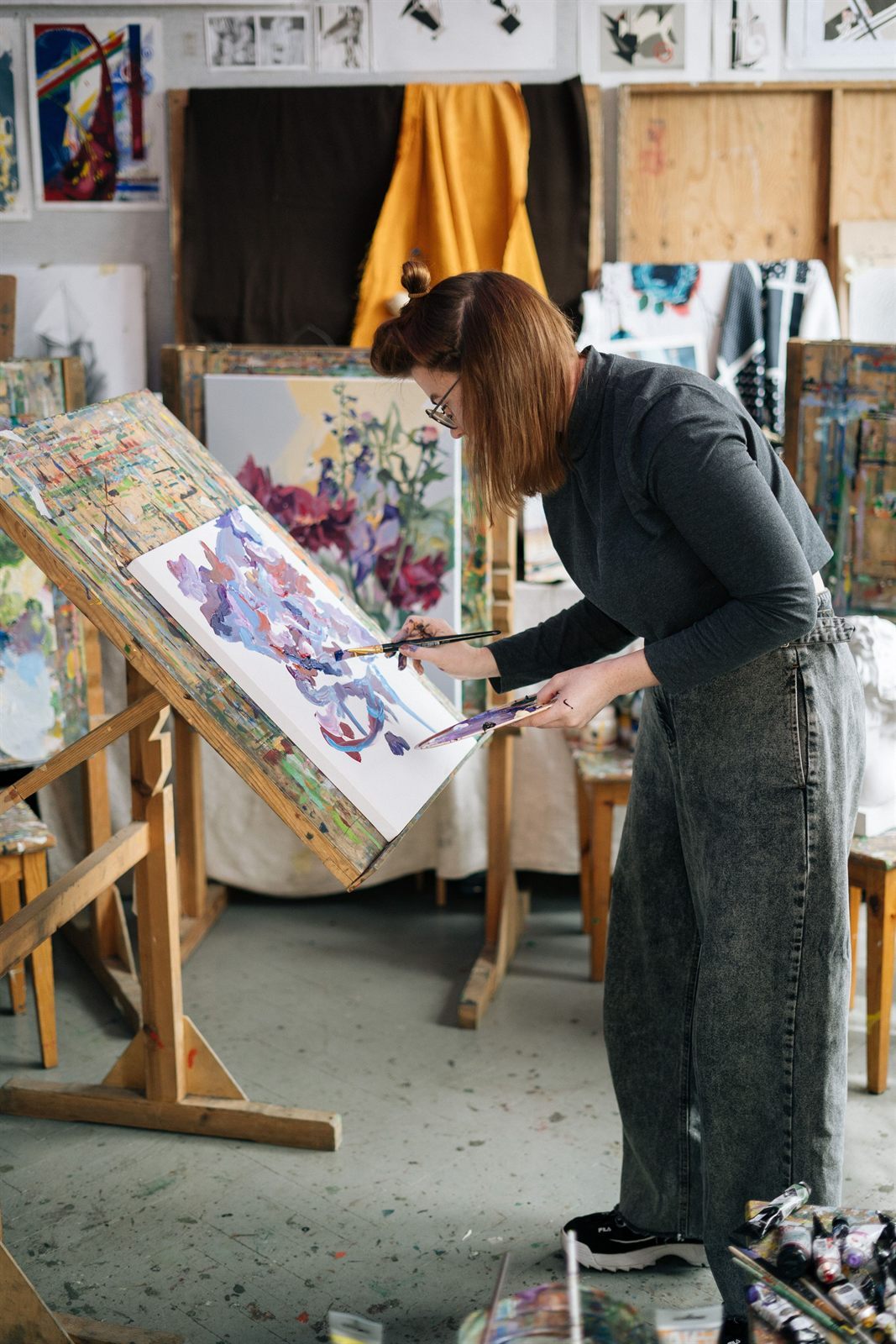 Linda Kane painting at an easel in her studio