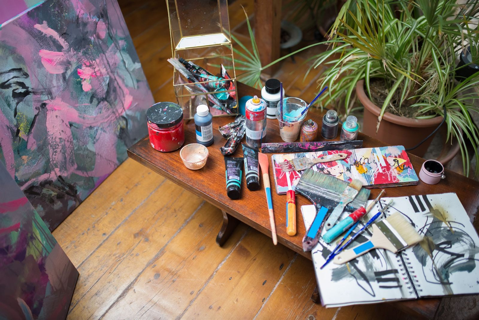 Brushes, tubes and mixing tools laid out on a studio table
